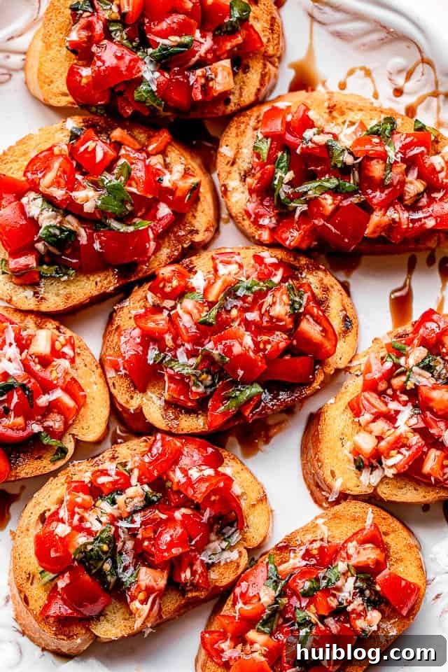 bread slices topped with tomato salad and served on a white platter