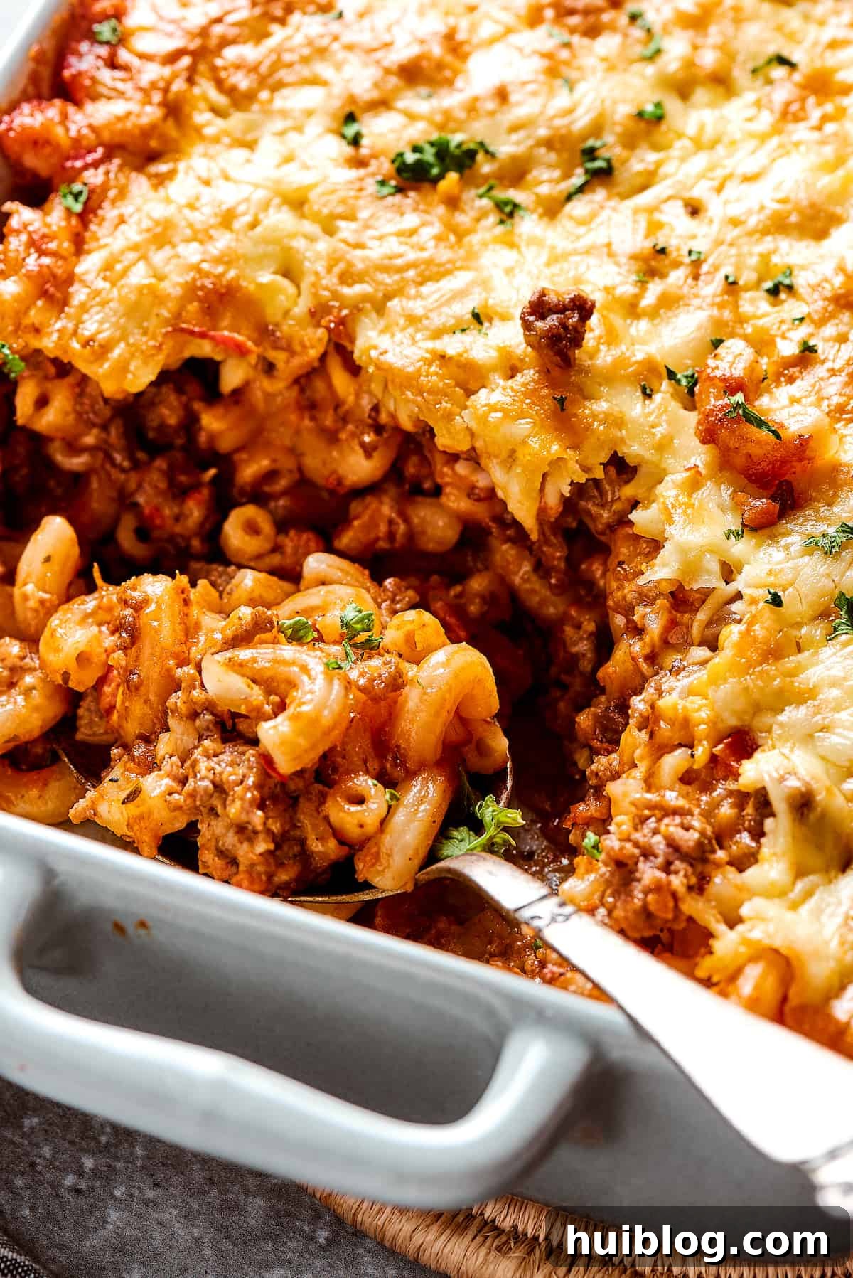 A casserole dish with a generous portion scooped out, a serving spoon resting within the dish, ready for more.