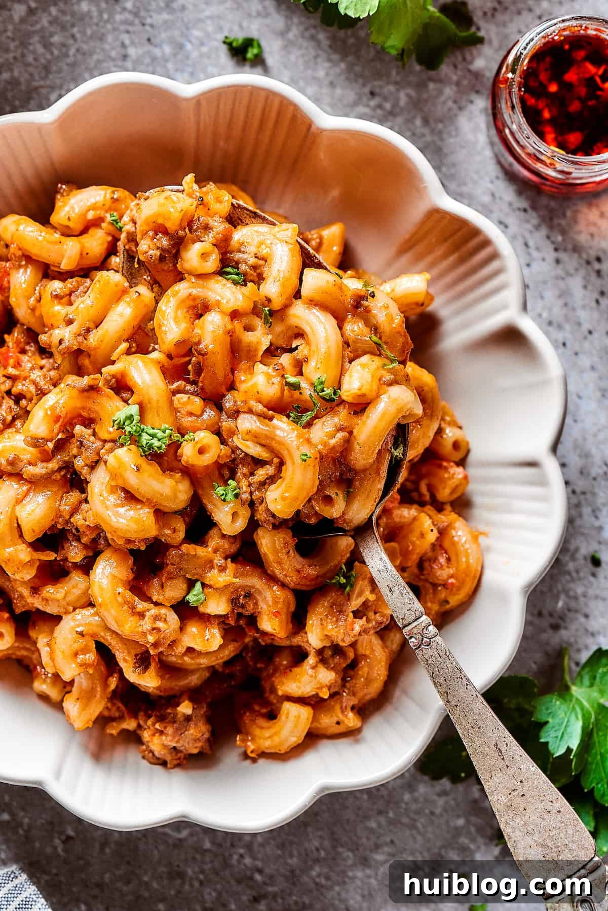 A bowl of creamy, cheesy beef and pasta casserole, ready to be enjoyed.