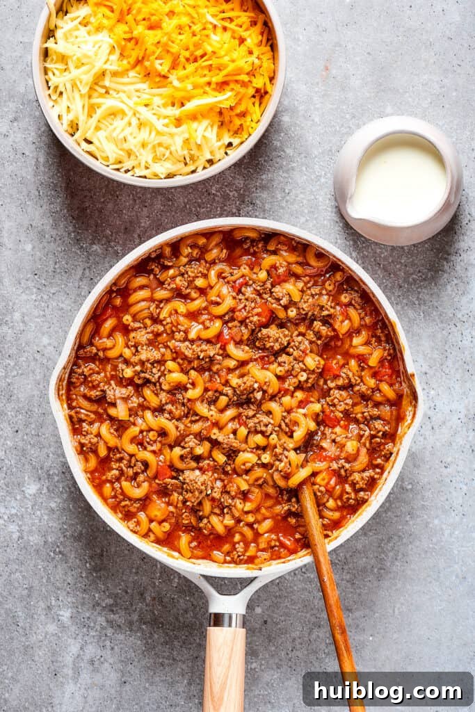 Macaroni pasta simmering gently in a rich, savory skillet sauce with beef.