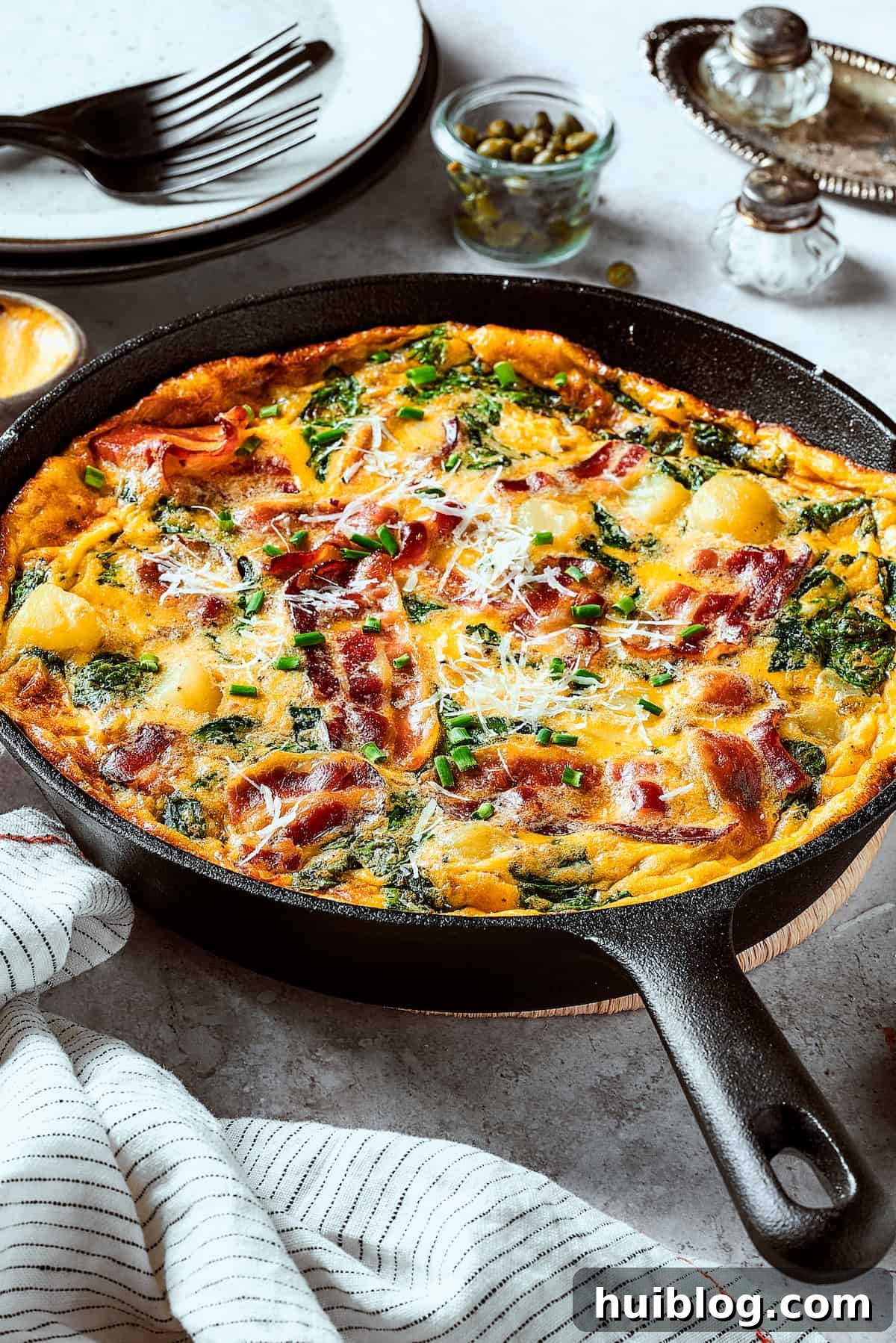 A baked egg dish in a cast-iron skillet, beautifully golden brown.