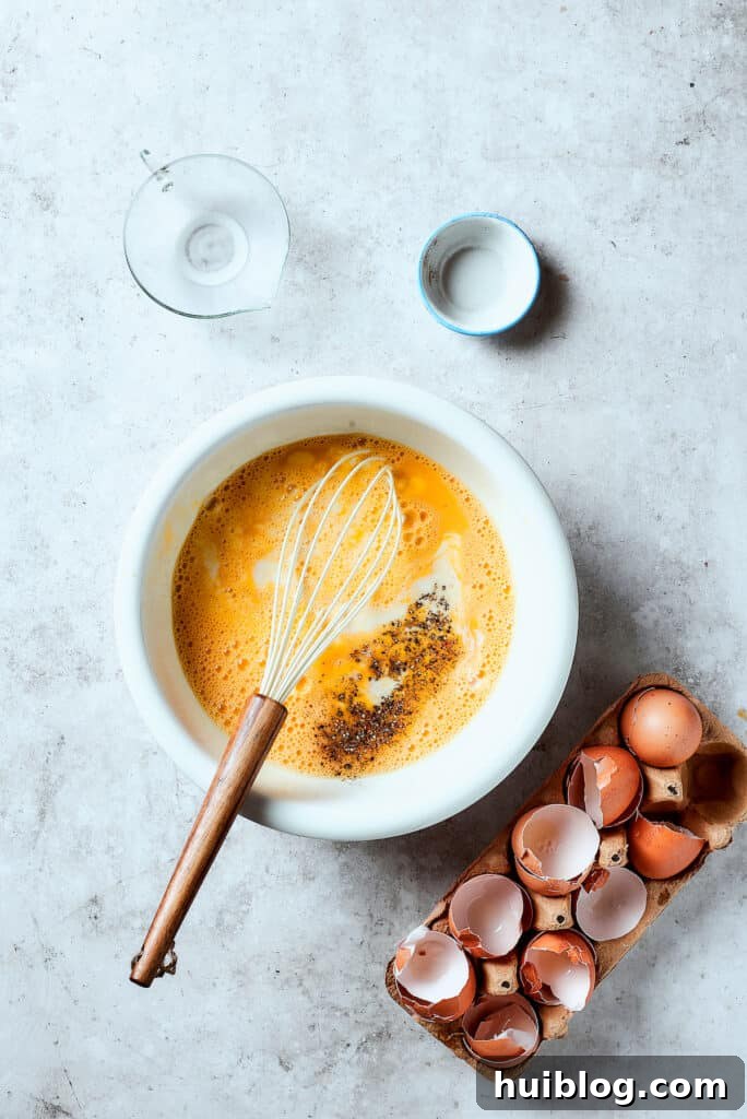Adding salt, pepper, and milk to eggs in a mixing bowl, preparing the frittata base.