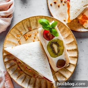 Overhead shot of fruit sandwich halves on a plate.