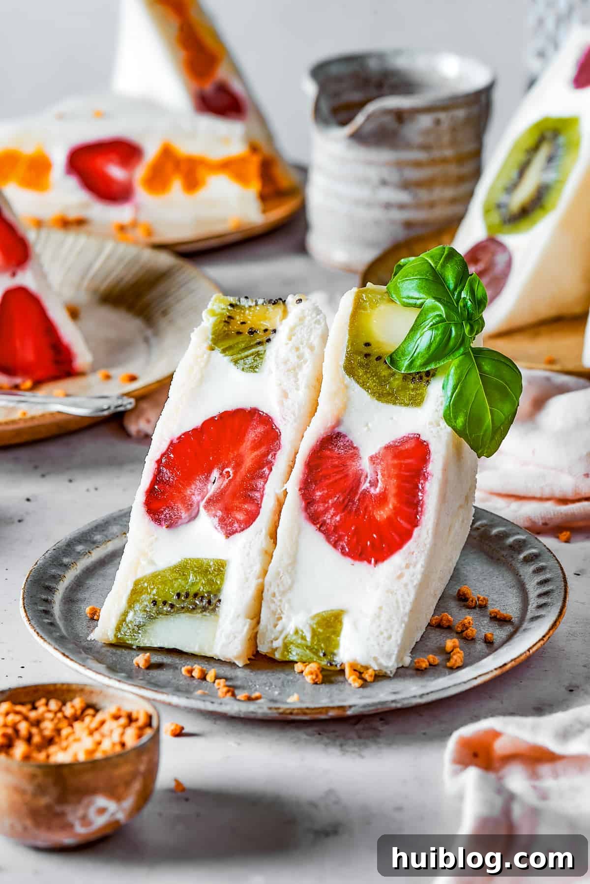 A sliced kiwi and strawberry fruit sando on a small plate, showing the beautiful cross-section.