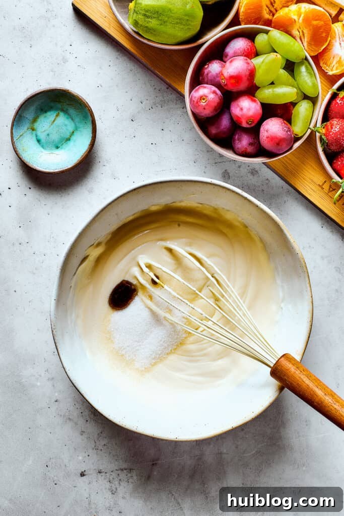 Whipping heavy cream with sugar and vanilla in a bowl until stiff peaks form.
