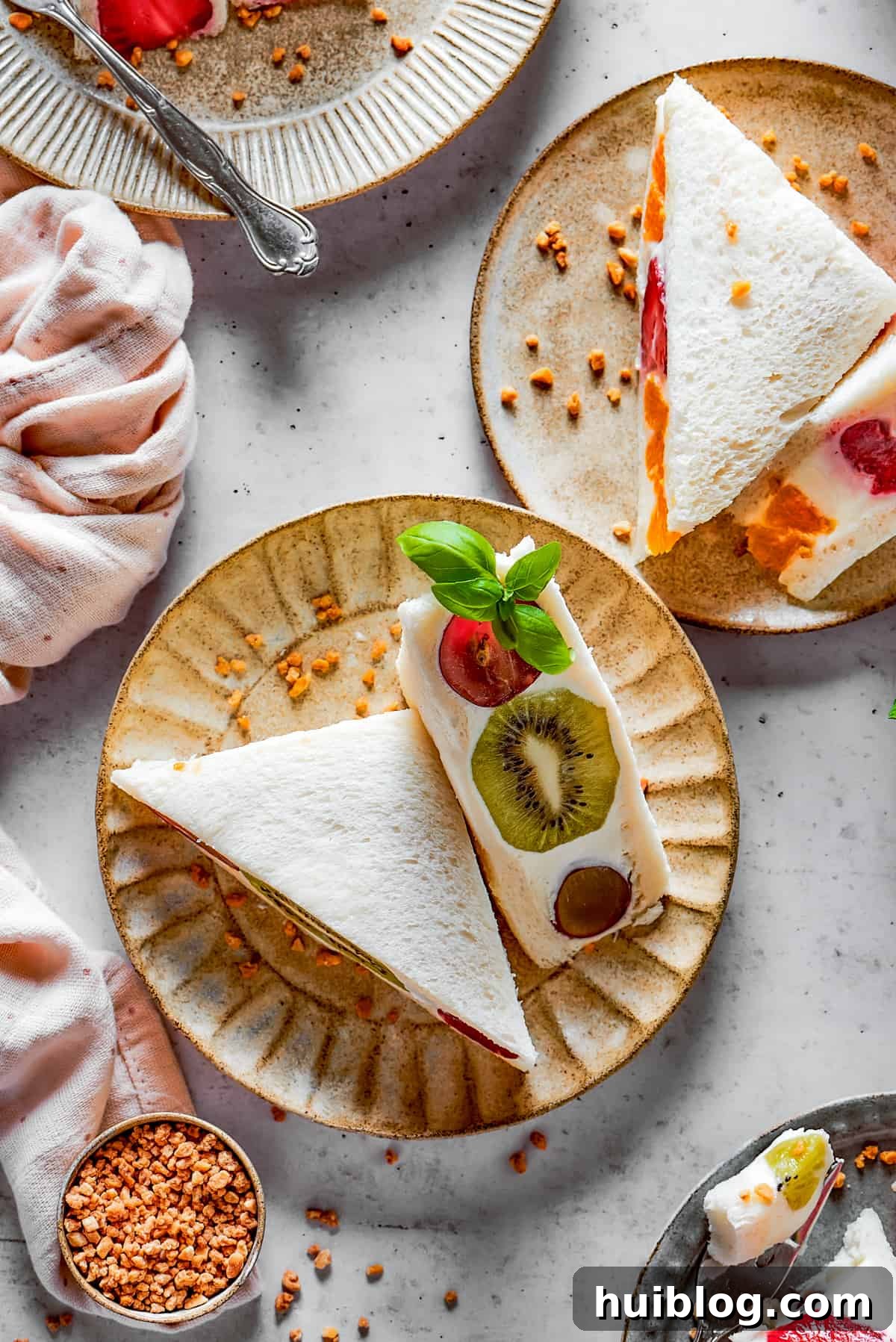 Beautifully presented fruit sandwiches on small, decorative plates, ready to be enjoyed.