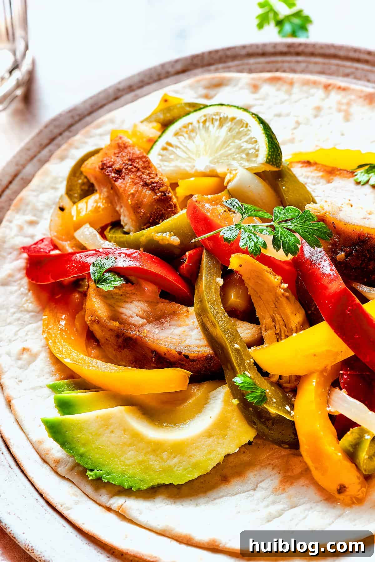 Close-up shot of warm flour tortillas generously filled with tender chicken fajitas and vibrant vegetables.