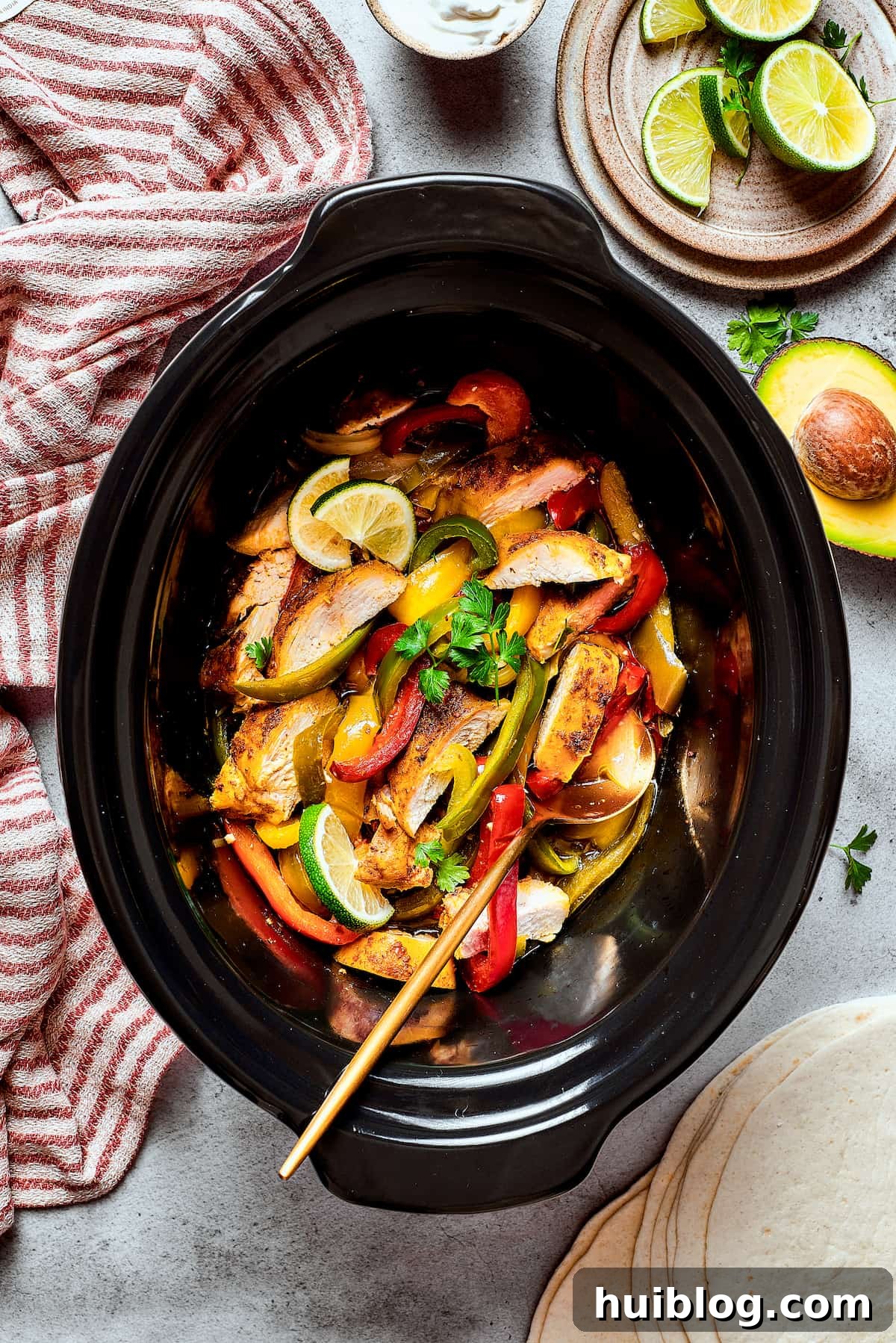 A slow cooker filled with aromatic Southwest-style chicken, vibrant bell peppers, and caramelized onions, perfectly cooked and ready to serve.