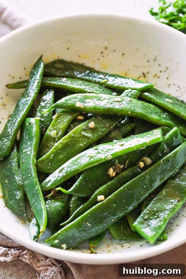 Romano Beans cooked in Garlic Butter are a delicious blend of healthy and tasty, easily prepared in no time! Blanched Italian Flat Beans served in a large white bowl, highlighting their flat, wide shape.