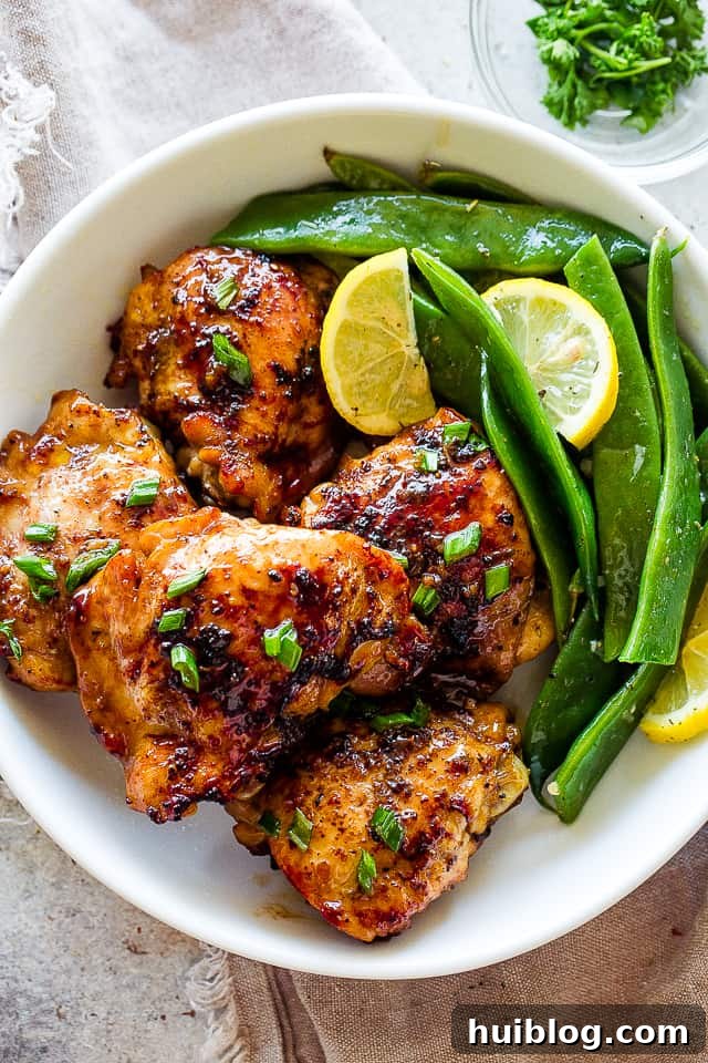 Romano Beans cooked in Garlic Butter are a delicious blend of healthy and tasty, easily prepared in no time! Romano flat beans served on a plate with browned chicken thighs, showcasing a complete meal.