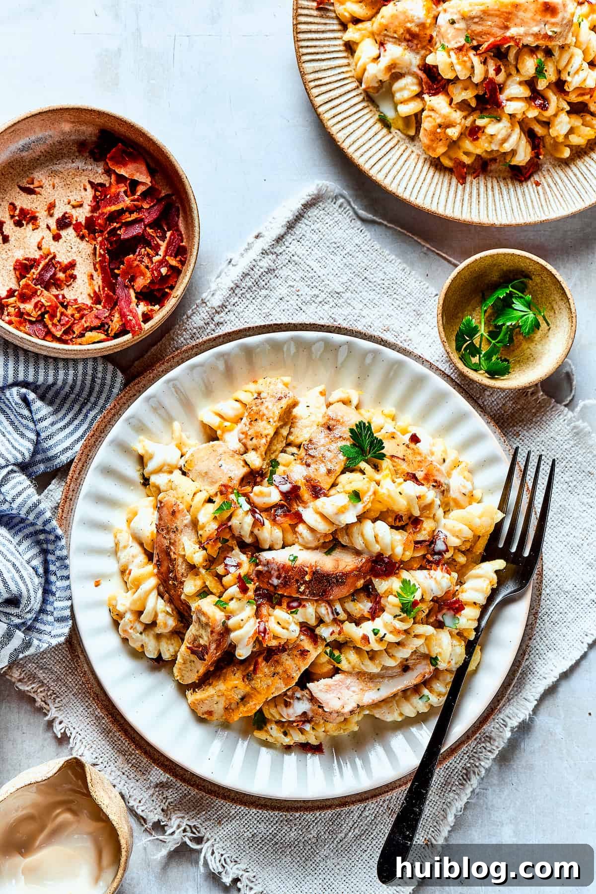 Delicious Chicken Bacon Ranch Pasta, a hearty and cozy meal. An overhead shot showcasing two servings of Chicken Bacon Ranch Pasta on dinner plates, invitingly arranged.