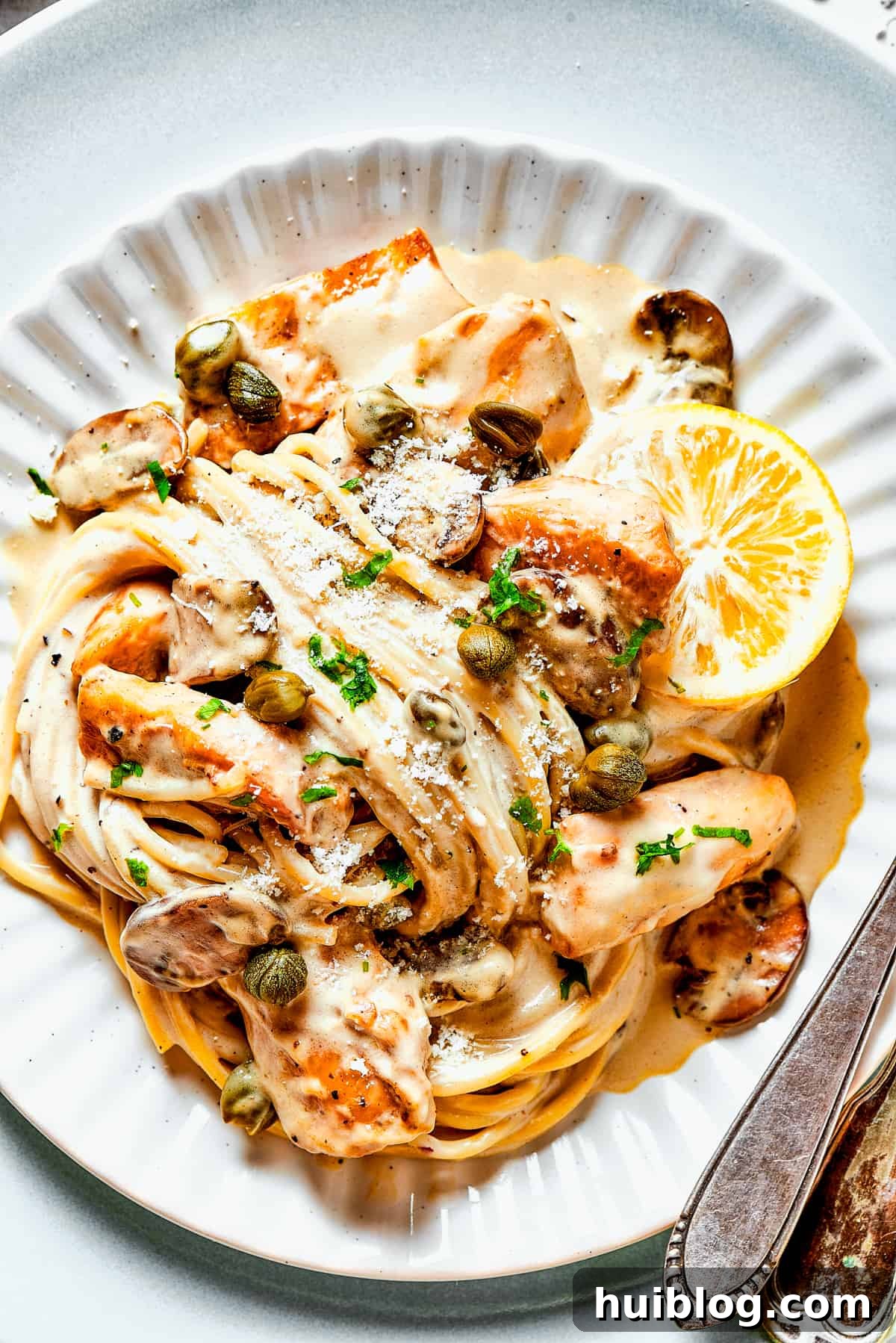 This chef’s-kiss-perfect Chicken Piccata Cheesecake Factory Copycat is loaded with juicy chicken, mushrooms, and pasta in a creamy sauce. Chicken piccata in caper-lemon sauce with pasta and served on a dinner plate.