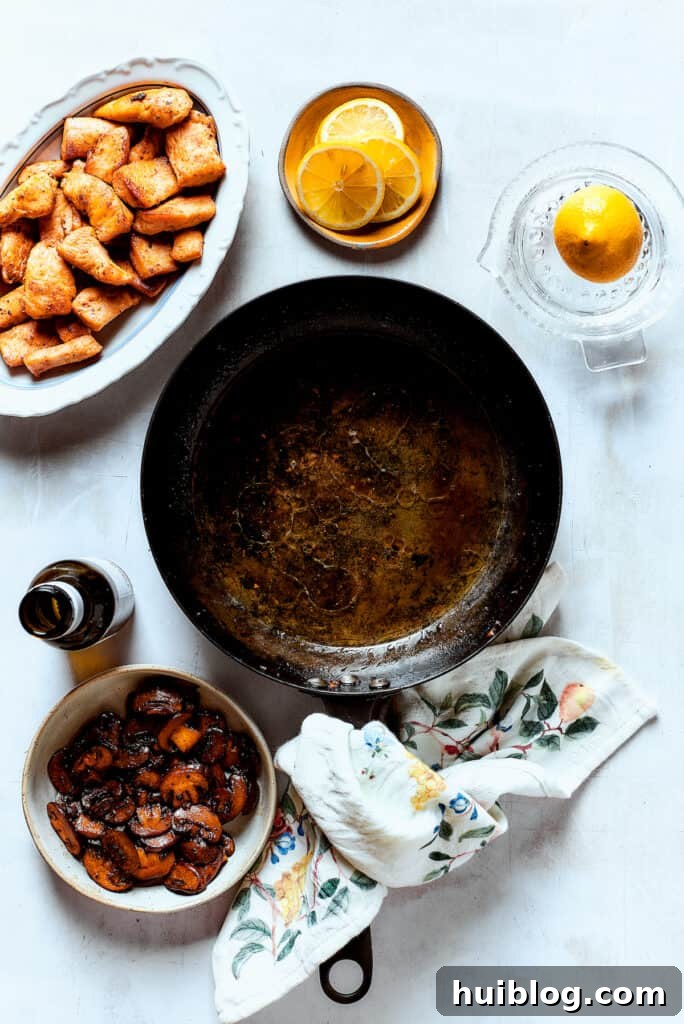 This chef’s-kiss-perfect Chicken Piccata Cheesecake Factory Copycat is loaded with juicy chicken, mushrooms, and pasta in a creamy sauce. Mushrooms and chicken cooked and set near a hot skillet.