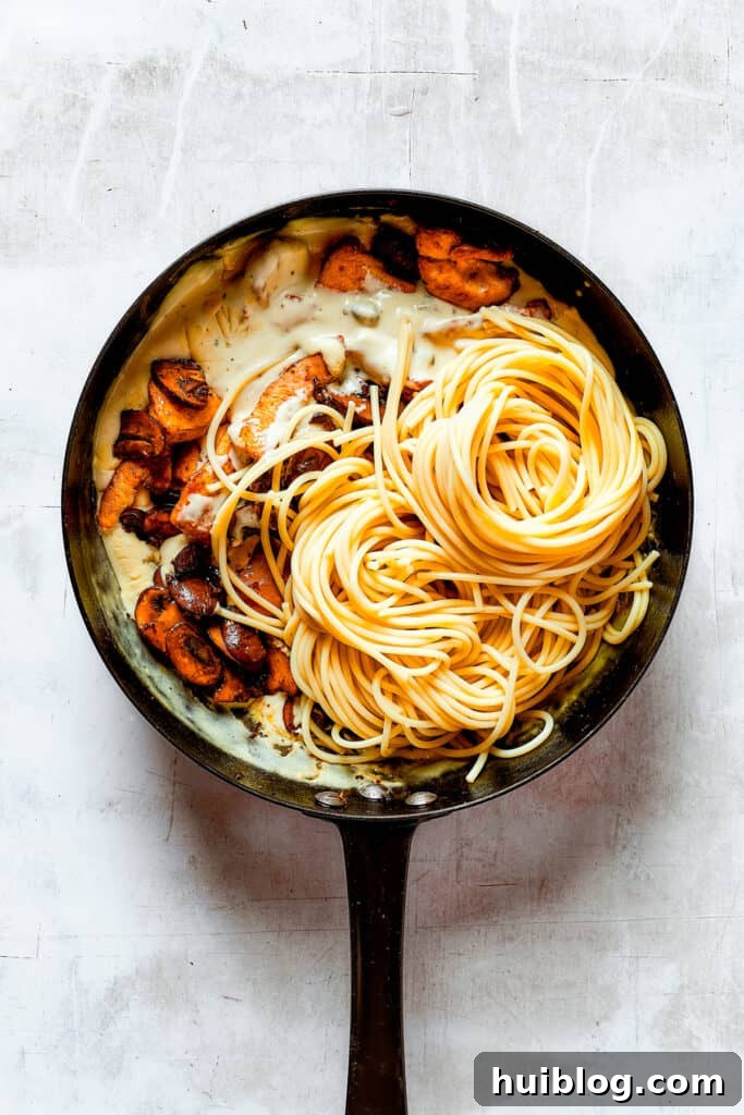 This chef’s-kiss-perfect Chicken Piccata Cheesecake Factory Copycat is loaded with juicy chicken, mushrooms, and pasta in a creamy sauce. Adding mushrooms, chicken, and pasta to a skillet.