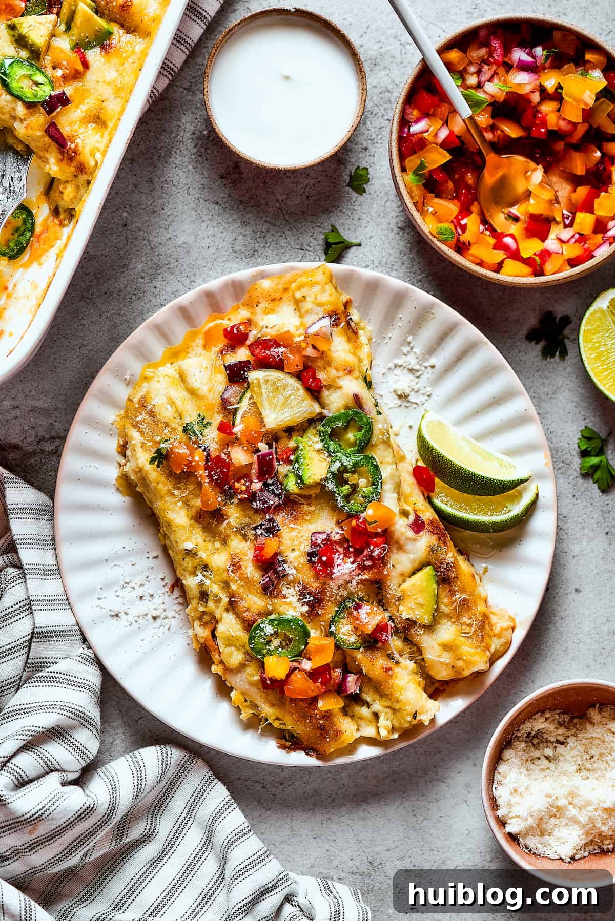 Shrimp Enchiladas are an easy, cheesy dinner with chopped shrimp and green enchilada sauce. The perfect balance of creamy, spicy, and savory! Two shrimp enchiladas on a plate.
