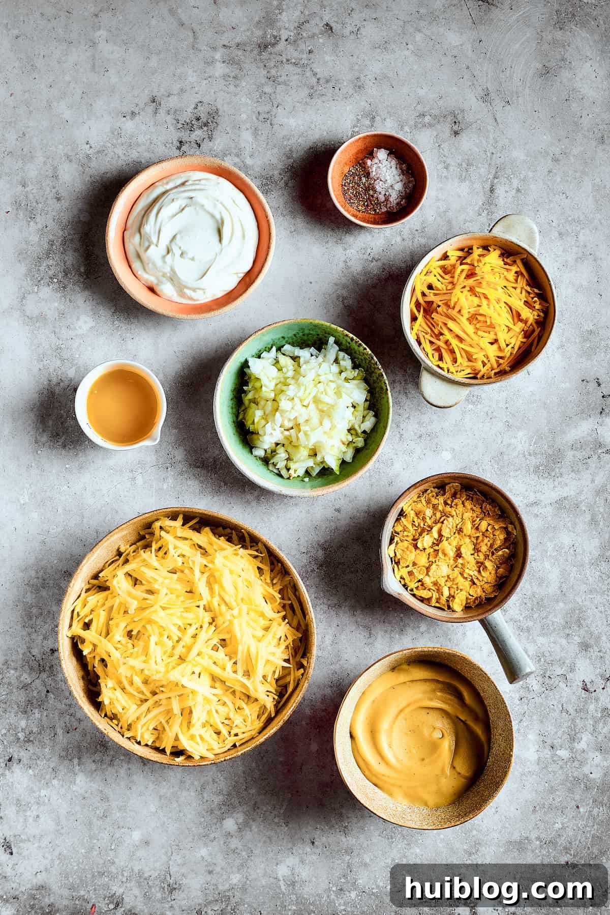 Ingredients for cheesy hashbrown casserole measured and arranged on a work surface.