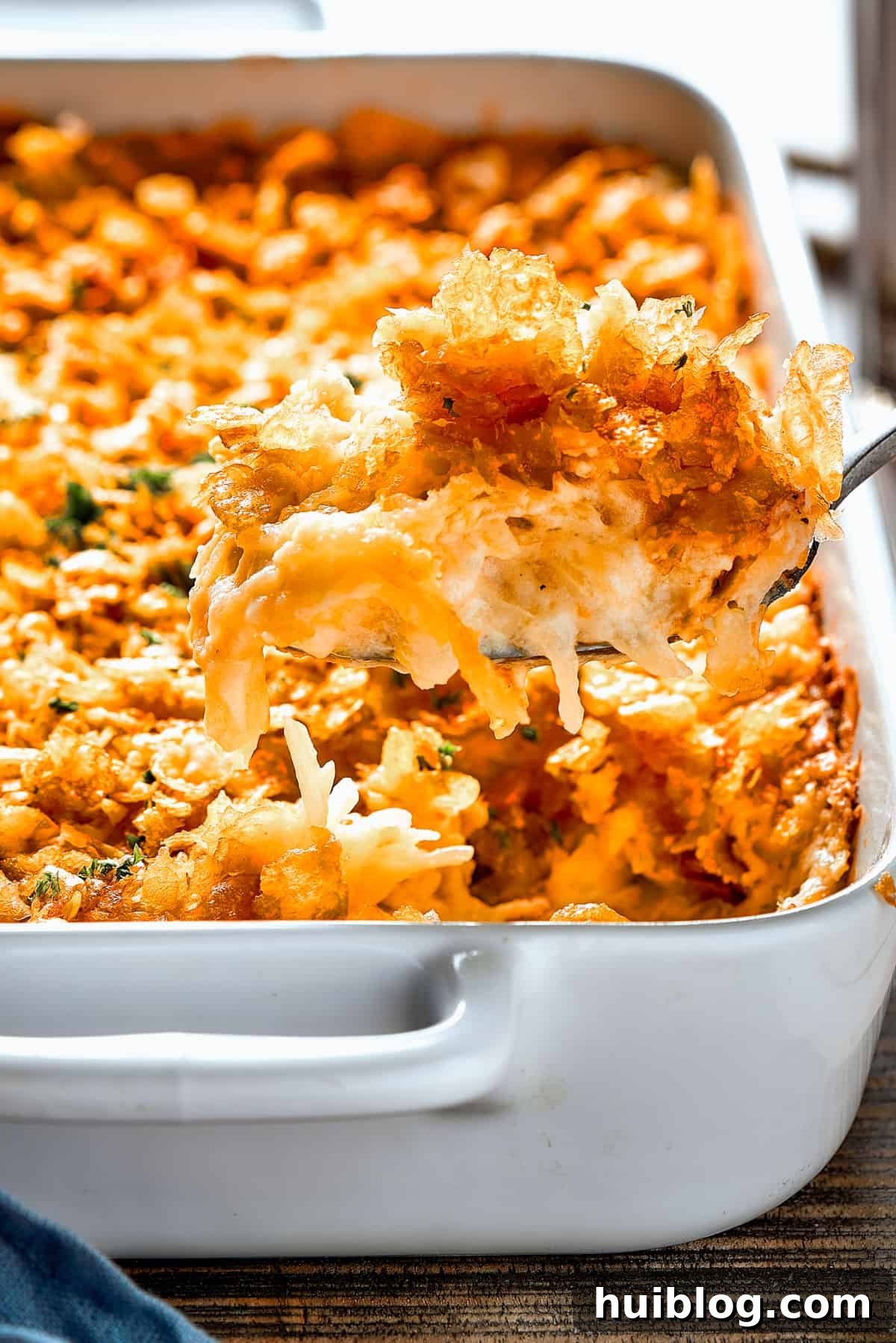 Spooning casserole out of a dish.