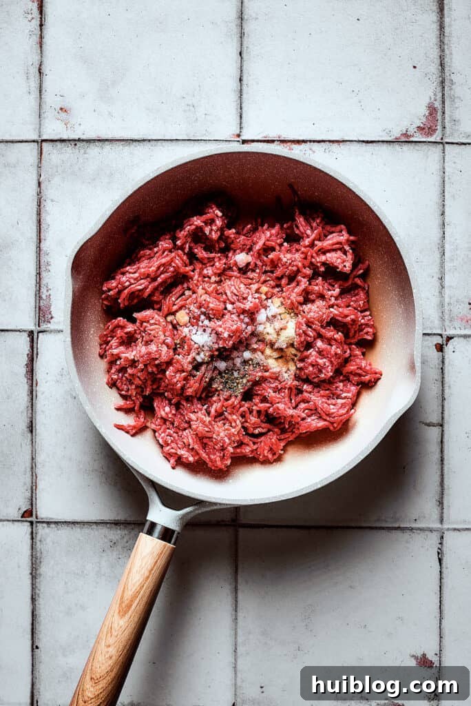 Cooking ground beef and seasonings in a skillet.