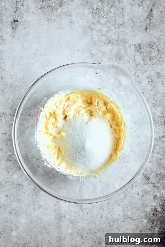 Creaming butter and sugar is the first step to wonderfully fluffy cupcakes. Softened butter and granulated sugar being creamed together in a mixing bowl until light and fluffy.
