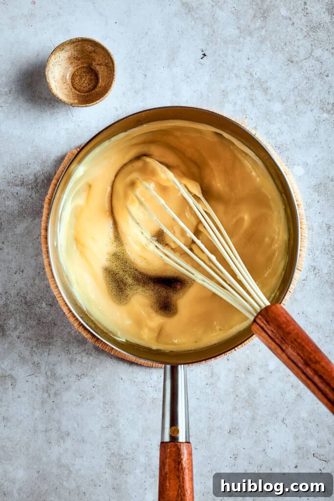 Southern Banana Pudding Cupcakes 3 The banana pudding mixture, now visibly thickened and smooth, bubbling gently in a saucepan, signaling it's almost ready.