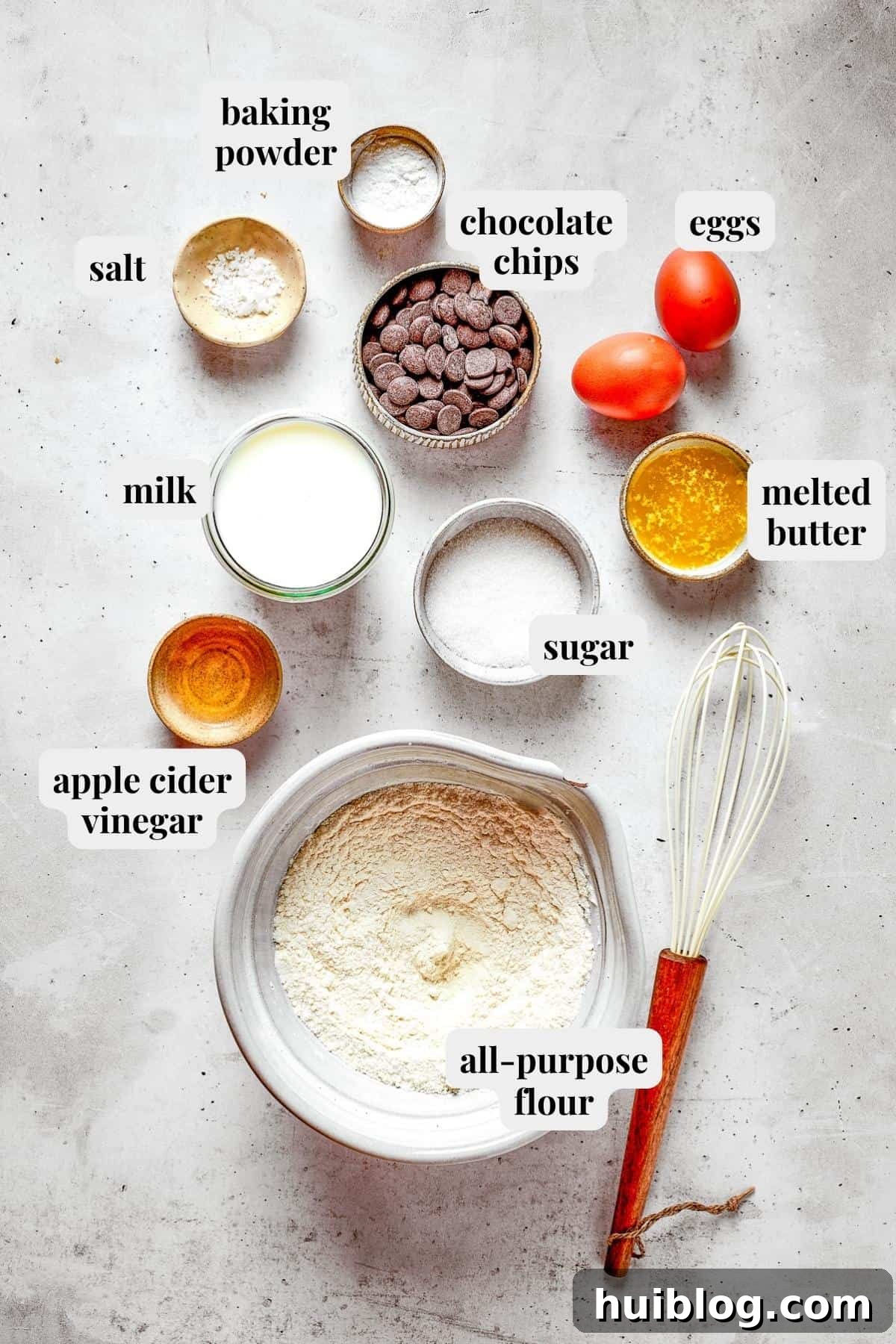 Photo of ingredients used to make Chocolate chip pancakes on a wooden surface.