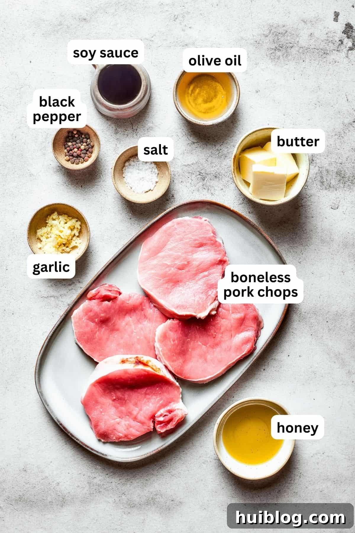 These Honey Garlic Pork Chops are the perfect blend of sweet-salty with a punch of extra flavor from minced garlic. Ready in 20 minutes! An overhead shot showcasing all the fresh ingredients meticulously arranged on a countertop, ready to be transformed into delicious honey garlic pork chops.