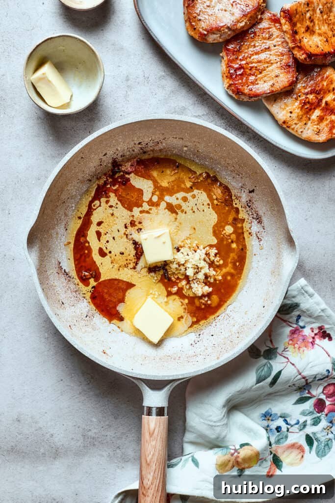 These Honey Garlic Pork Chops are the perfect blend of sweet-salty with a punch of extra flavor from minced garlic. Ready in 20 minutes! A knob of unsalted butter slowly melting in the same white skillet used for the pork, creating a rich base for the sauce.