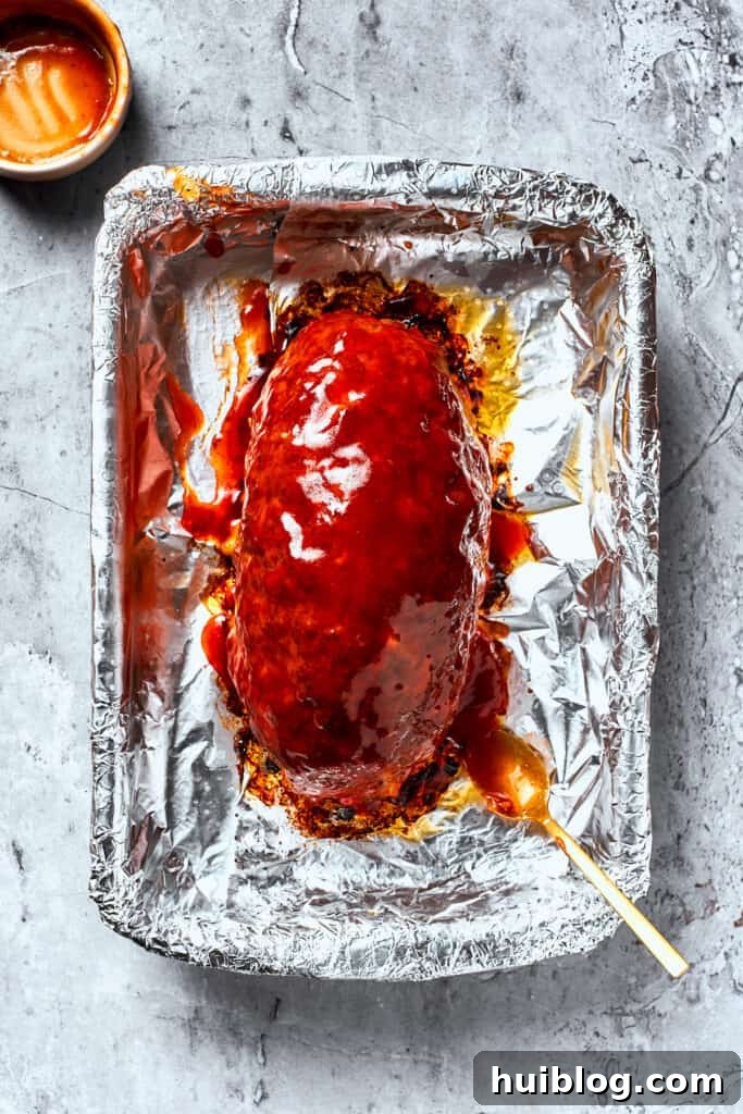 Comforting and hearty, Brown Sugar Meatloaf elevates ordinary meatloaf with a brown sugar-infused glaze for a hint of sweetness. A perfectly baked meatloaf, now completely topped with its rich brown sugar glaze, glowing from the oven.