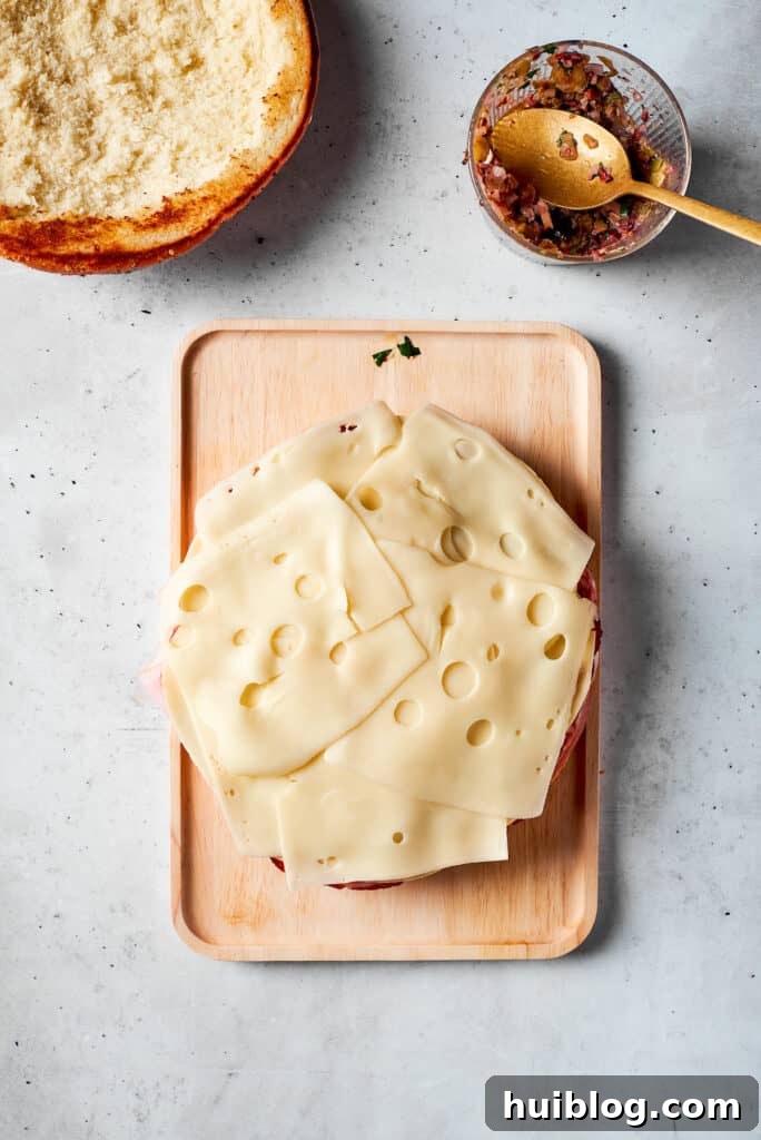 Creamy Swiss cheese slices are layered on top of the deli meats, adding a mild, nutty flavor.