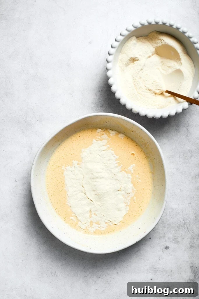 The previously prepared flour mixture is gently folded into the wet ingredients, forming the complete cake batter.