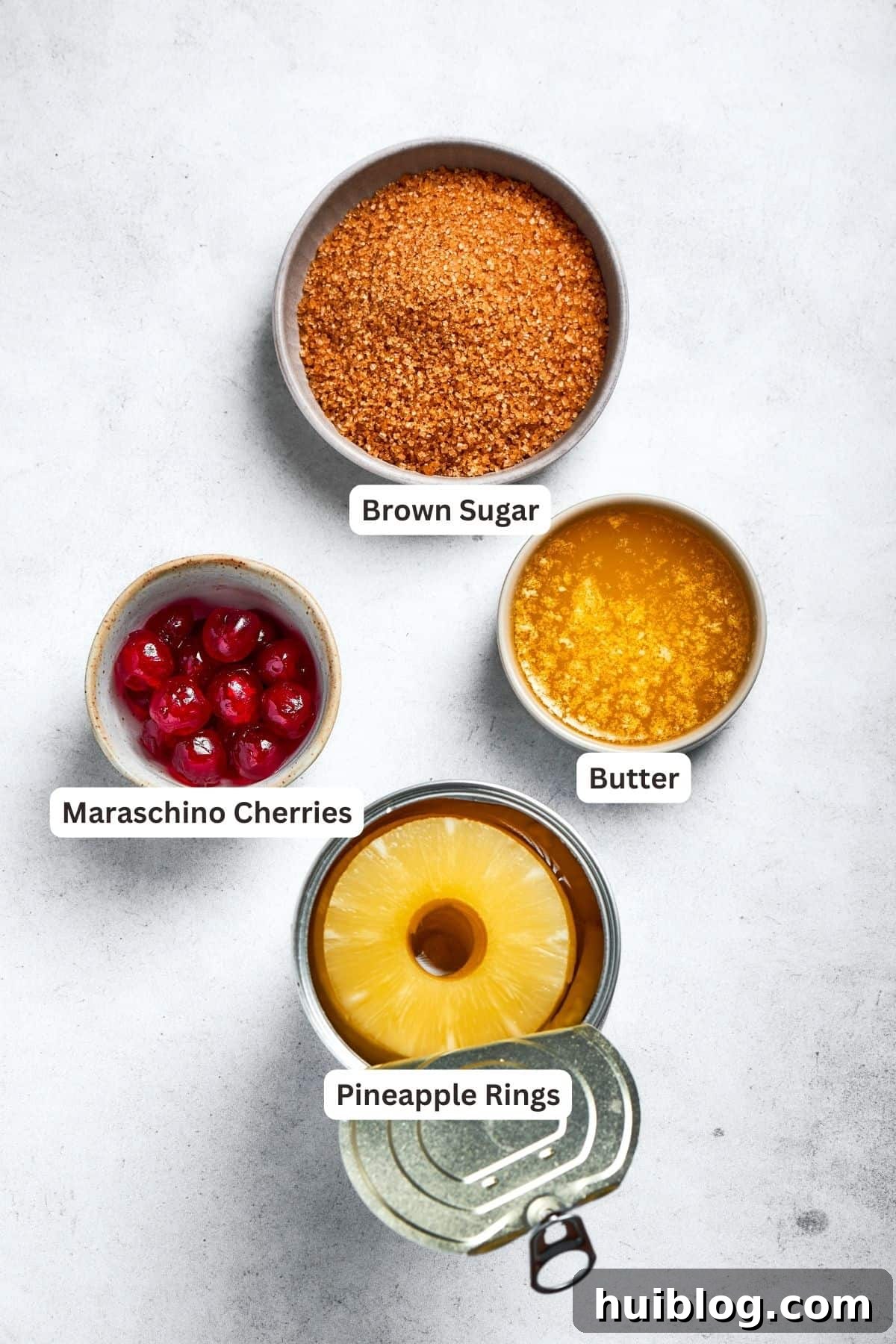 Topping ingredients laid out: pineapple rings, unsalted butter, light brown sugar, and maraschino cherries.