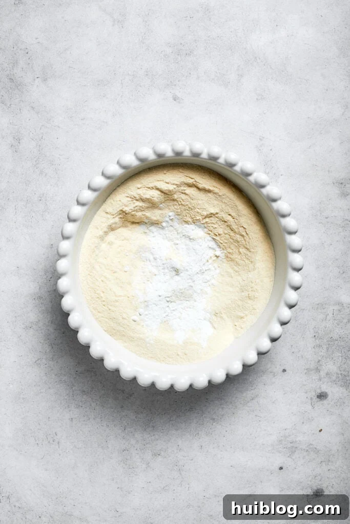 A bowl containing a mixture of flour, baking powder, and salt, representing the dry ingredients for the cake batter.