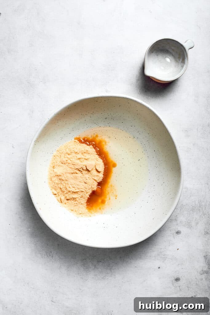 Vegetable oil and granulated sugar are added to a mixing bowl, ready to be combined.