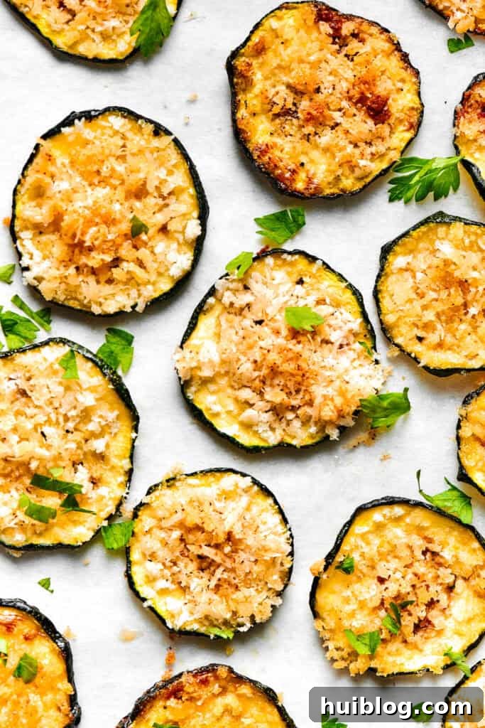 Slices of perfectly baked golden-brown zucchini arranged neatly on a light surface, ready to serve.