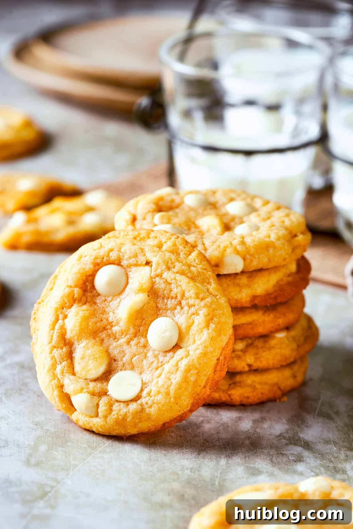 Stacked up white chocolate chip cookies, showcasing their inviting texture and delicious appearance.
