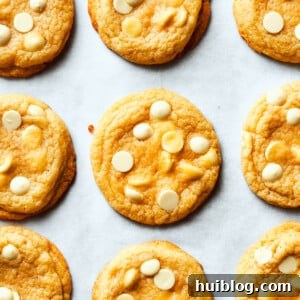 Nine perfectly baked chewy white chocolate chip cookies arranged neatly on a crisp white background, showcasing their golden edges and melt-in-your-mouth centers dotted with sweet white chocolate.