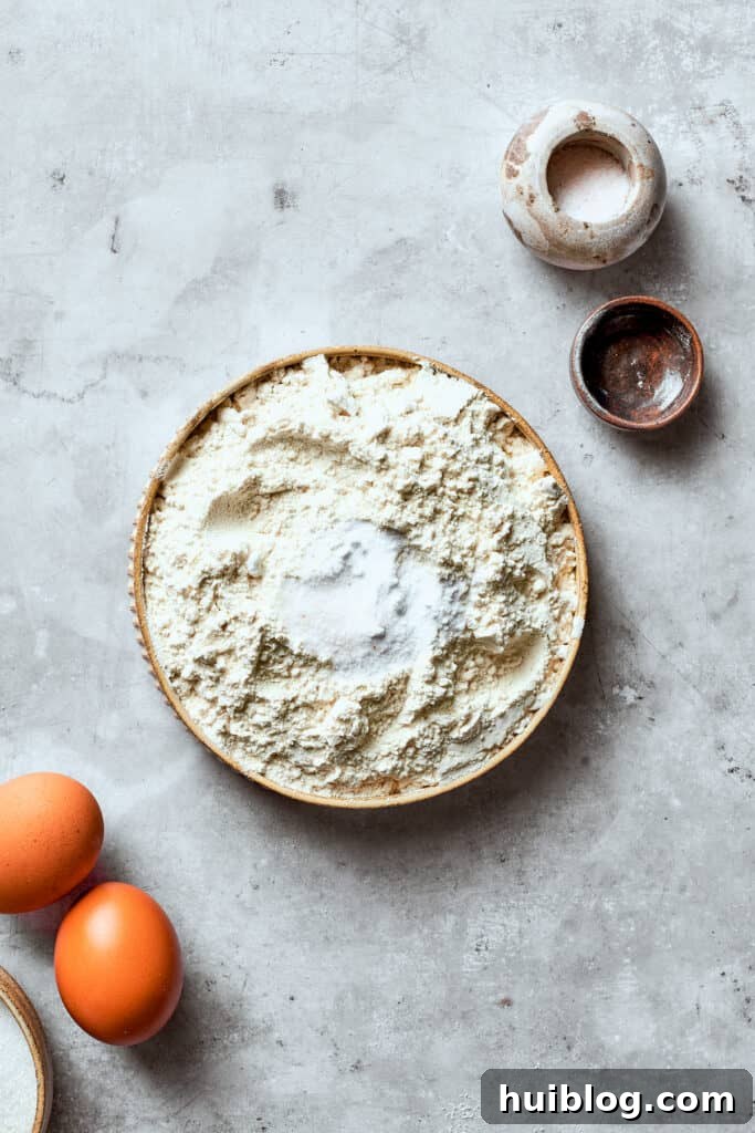 The dry mix for white chocolate chip cookie dough is added to a bowl, showing the flour, salt, and baking soda combined.