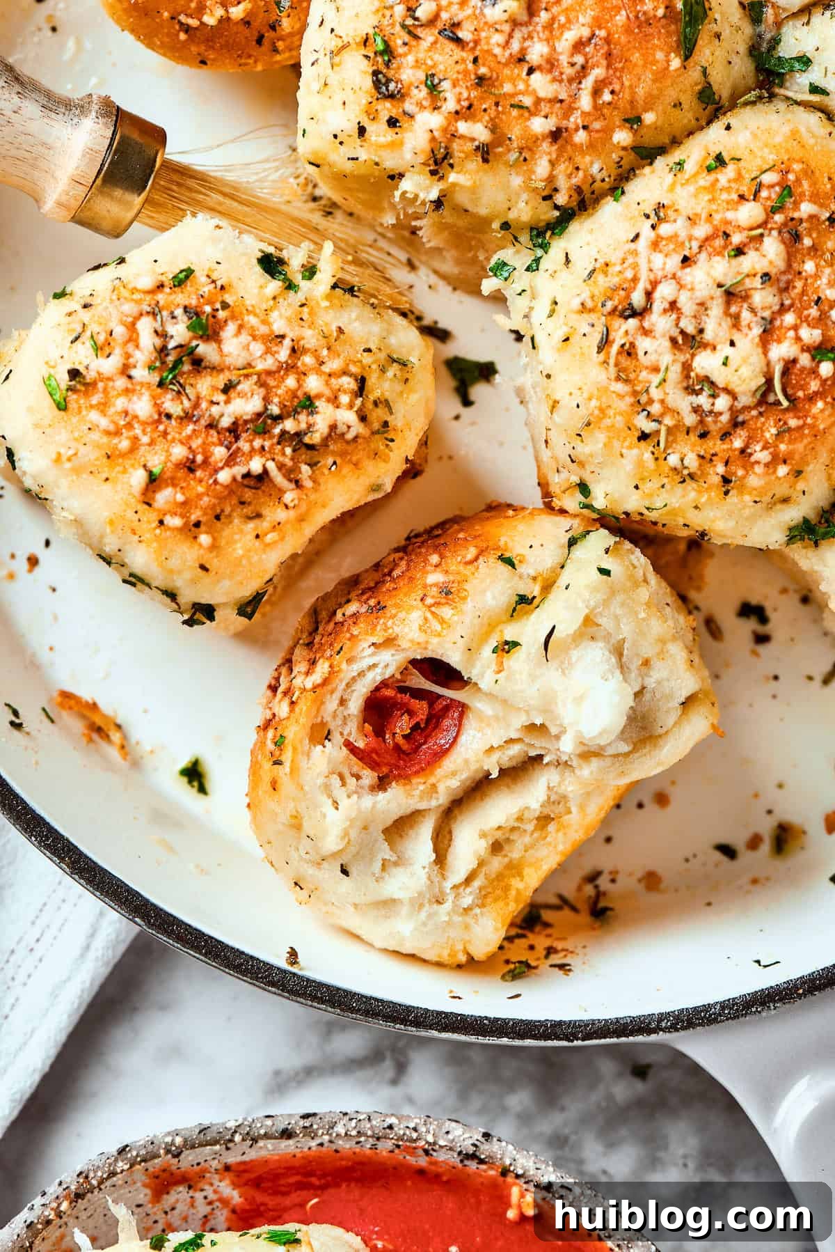 Golden brown pizza bites resting in a cast iron skillet. A few pizza bites are shown in a skillet, freshly baked and golden.