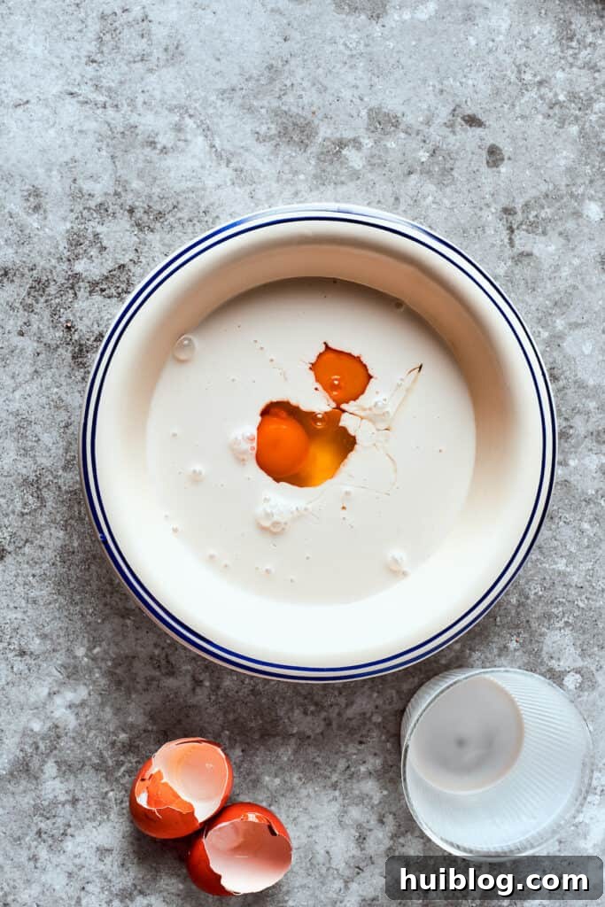 Egg is mixed into a bowl of milk.
