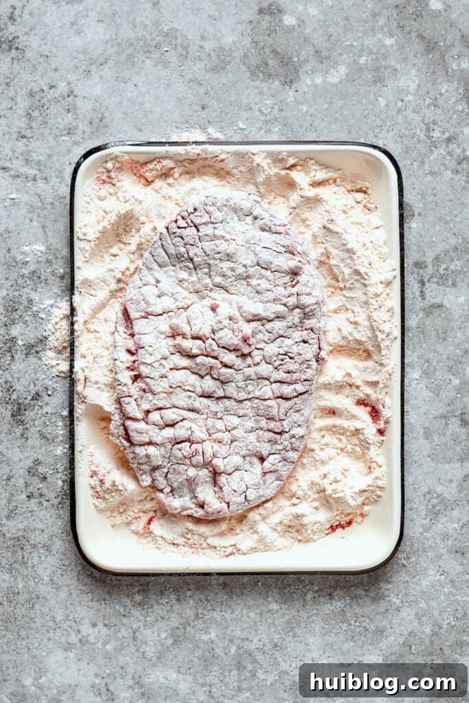 The other side of the steak is coated in flour.