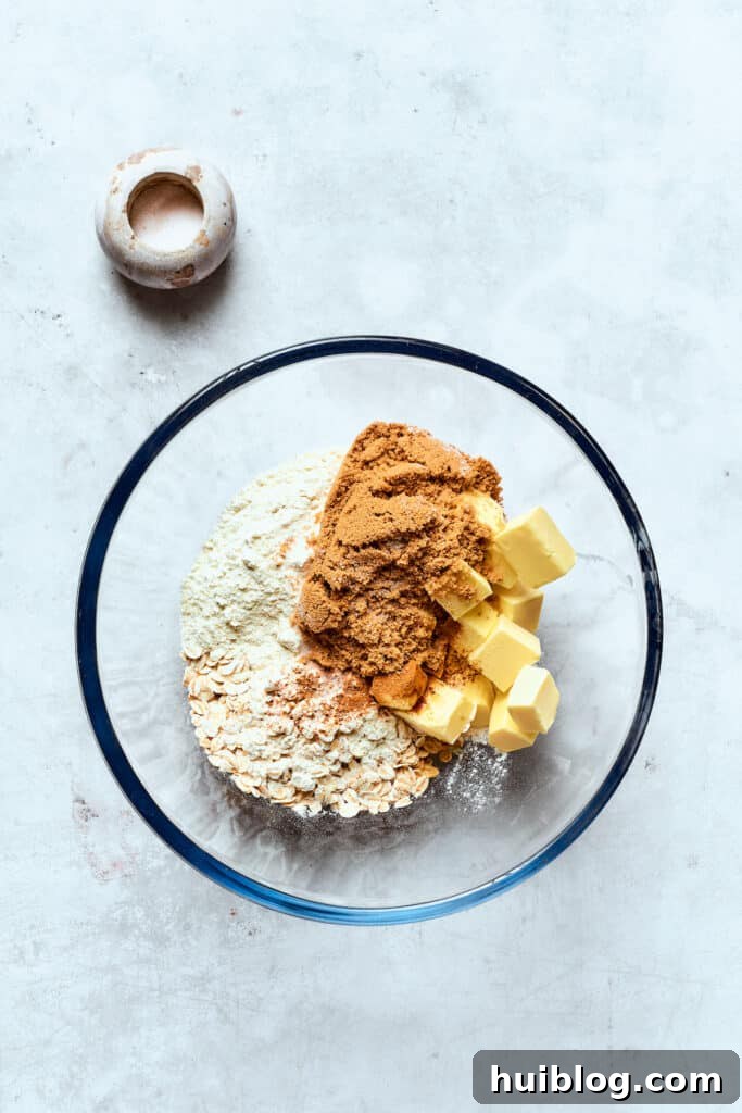 The blueberry crisp topping ingredients are added to a bowl.