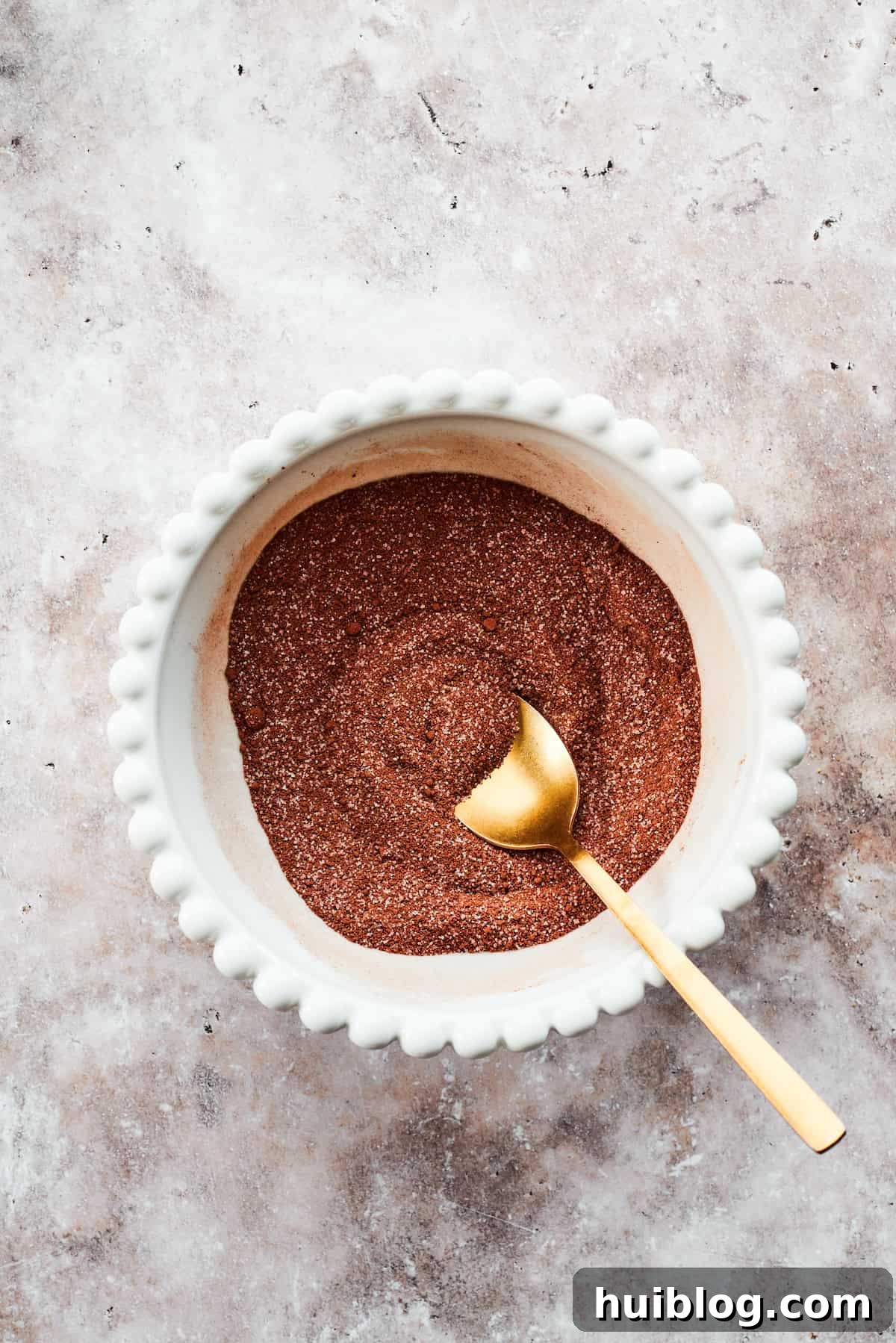 A spoon mixes the fudge topping.
