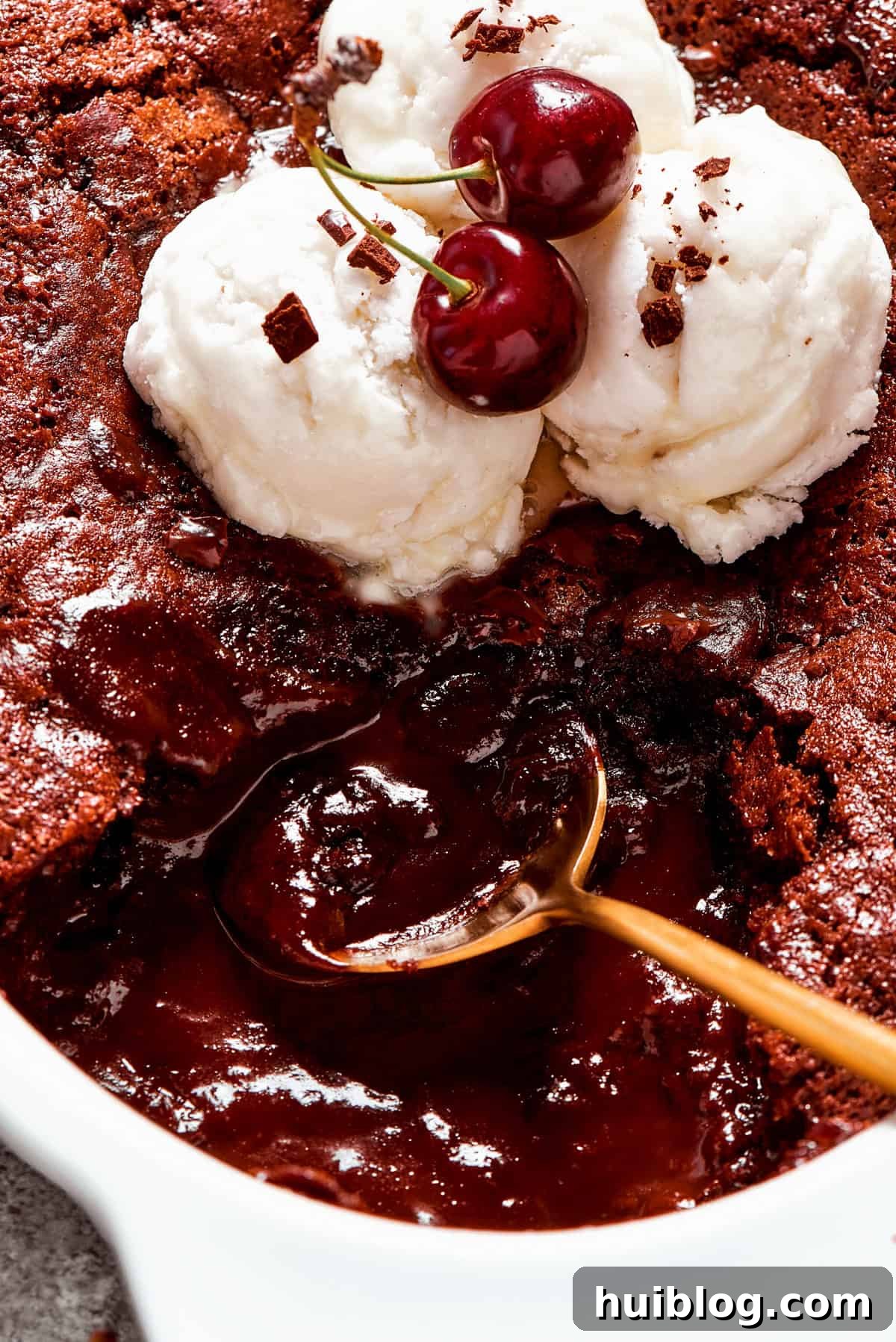 Close-up image of a spoon stirring through chocolate pudding cake.