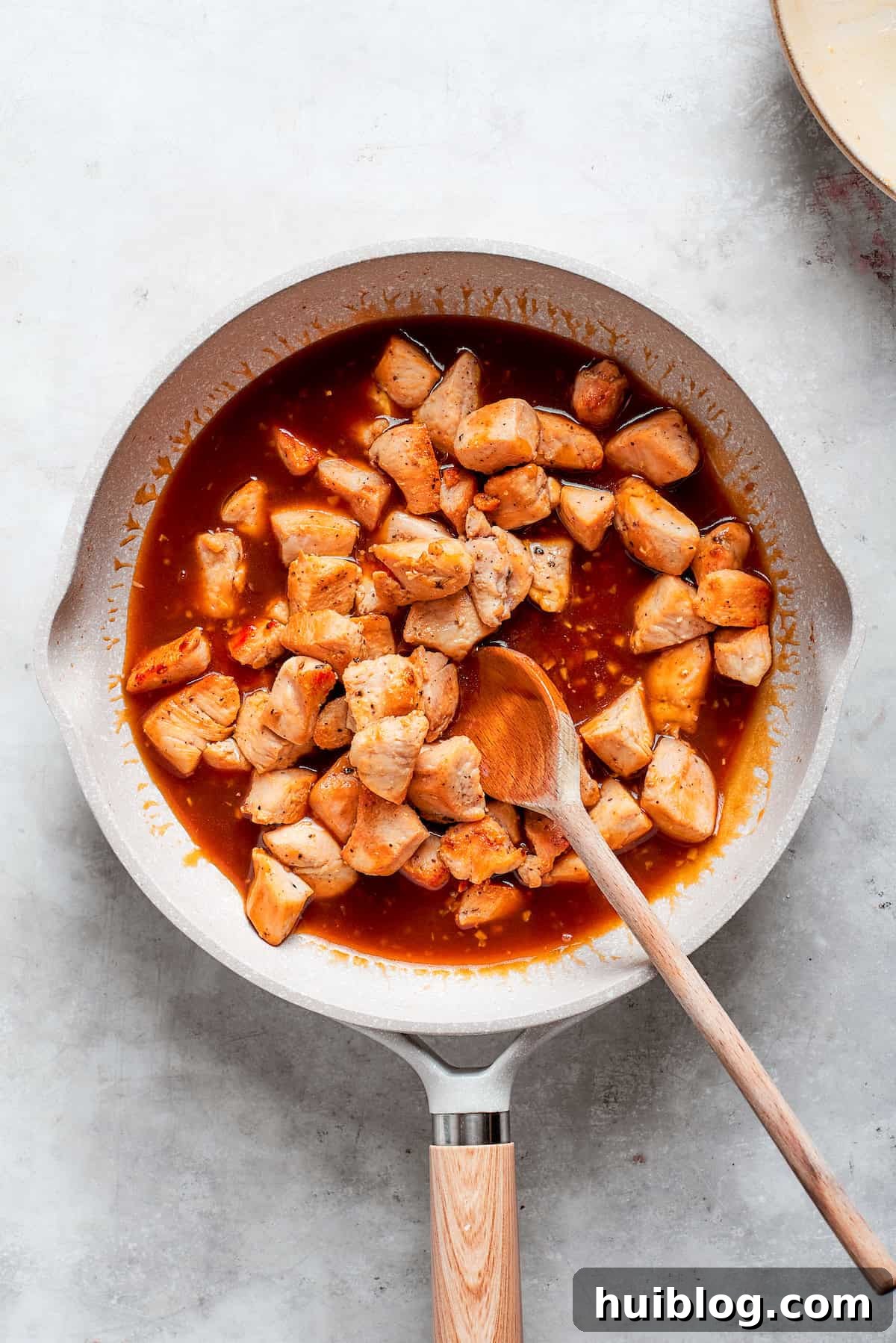 The chicken is added back to the pan of sauce.