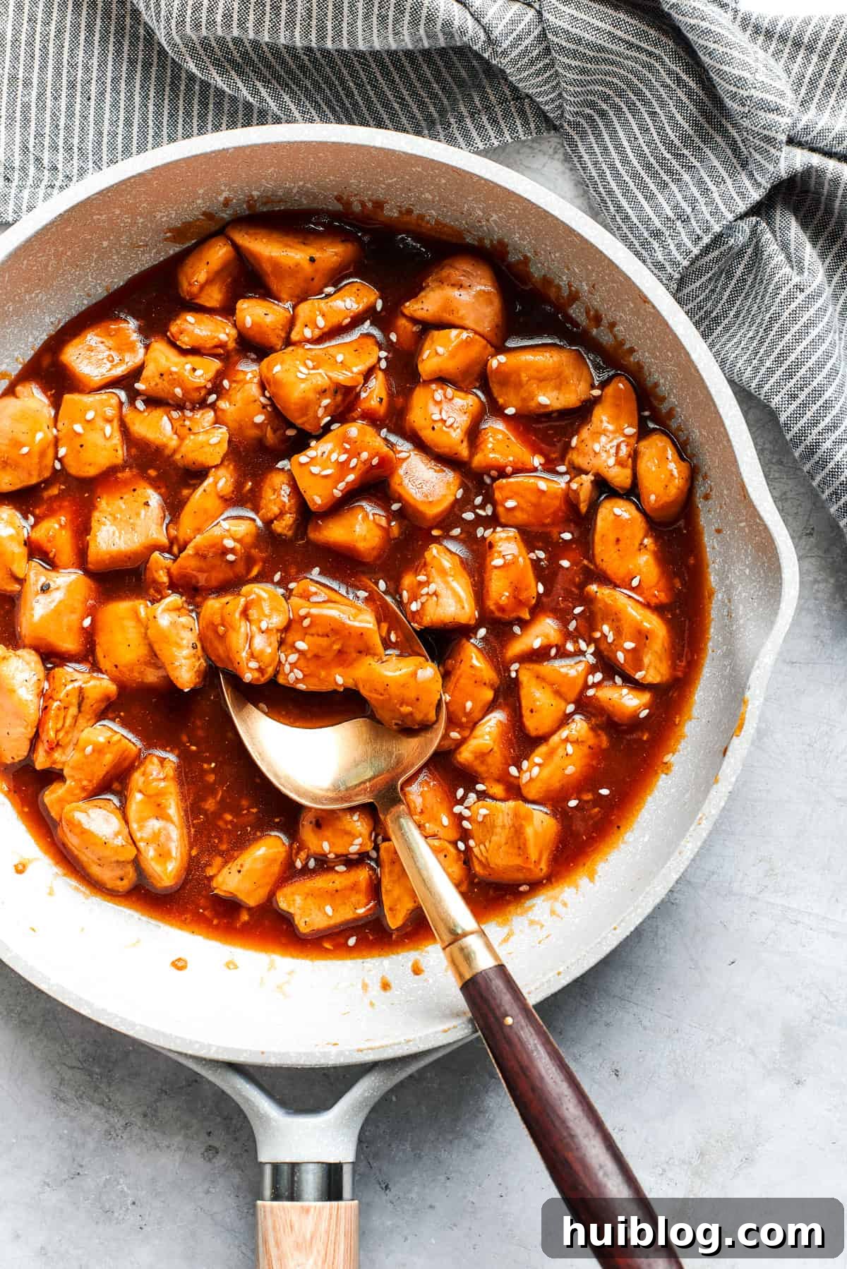 Perfectly Glazed Teriyaki Chicken 5 Cubes of chicken cooking in a sauce.
