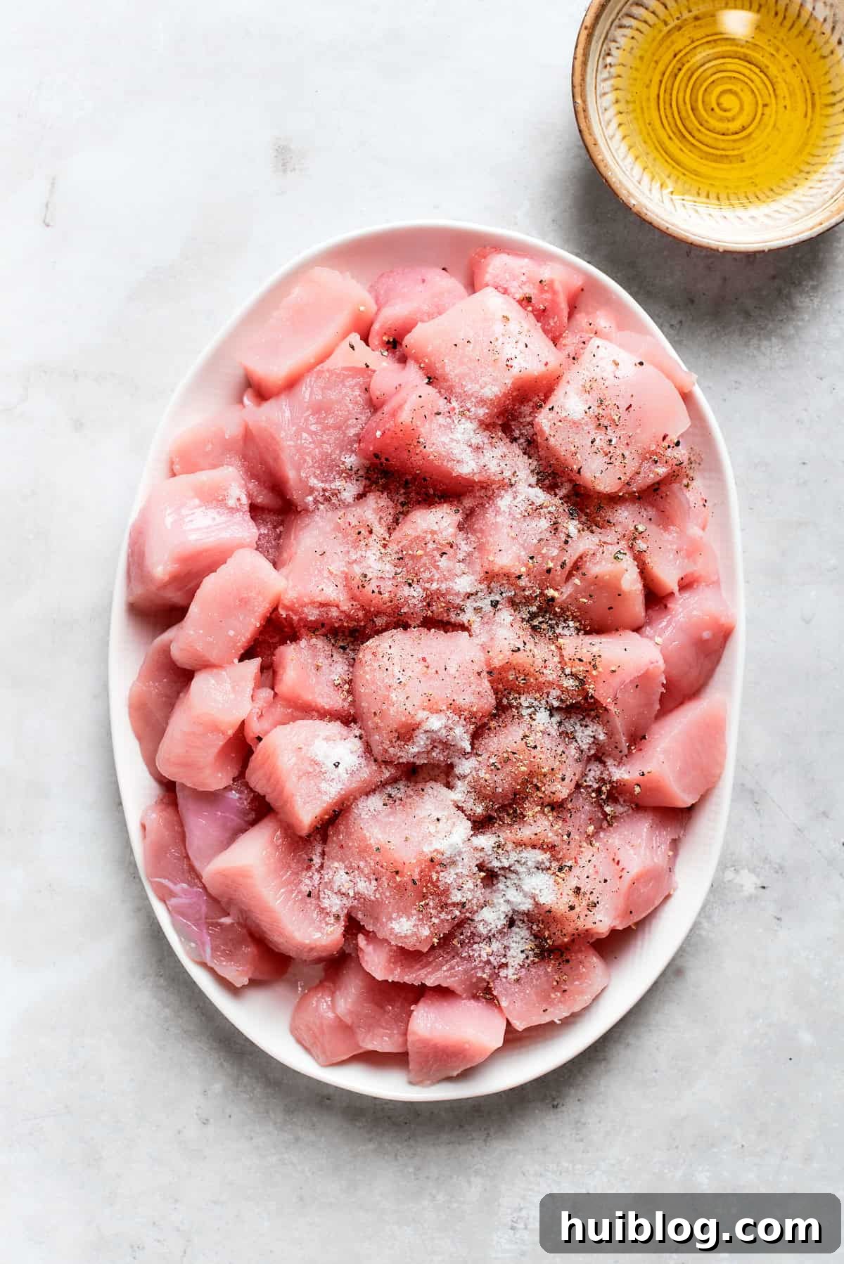 Chicken pieces are seasoned with salt and pepper.