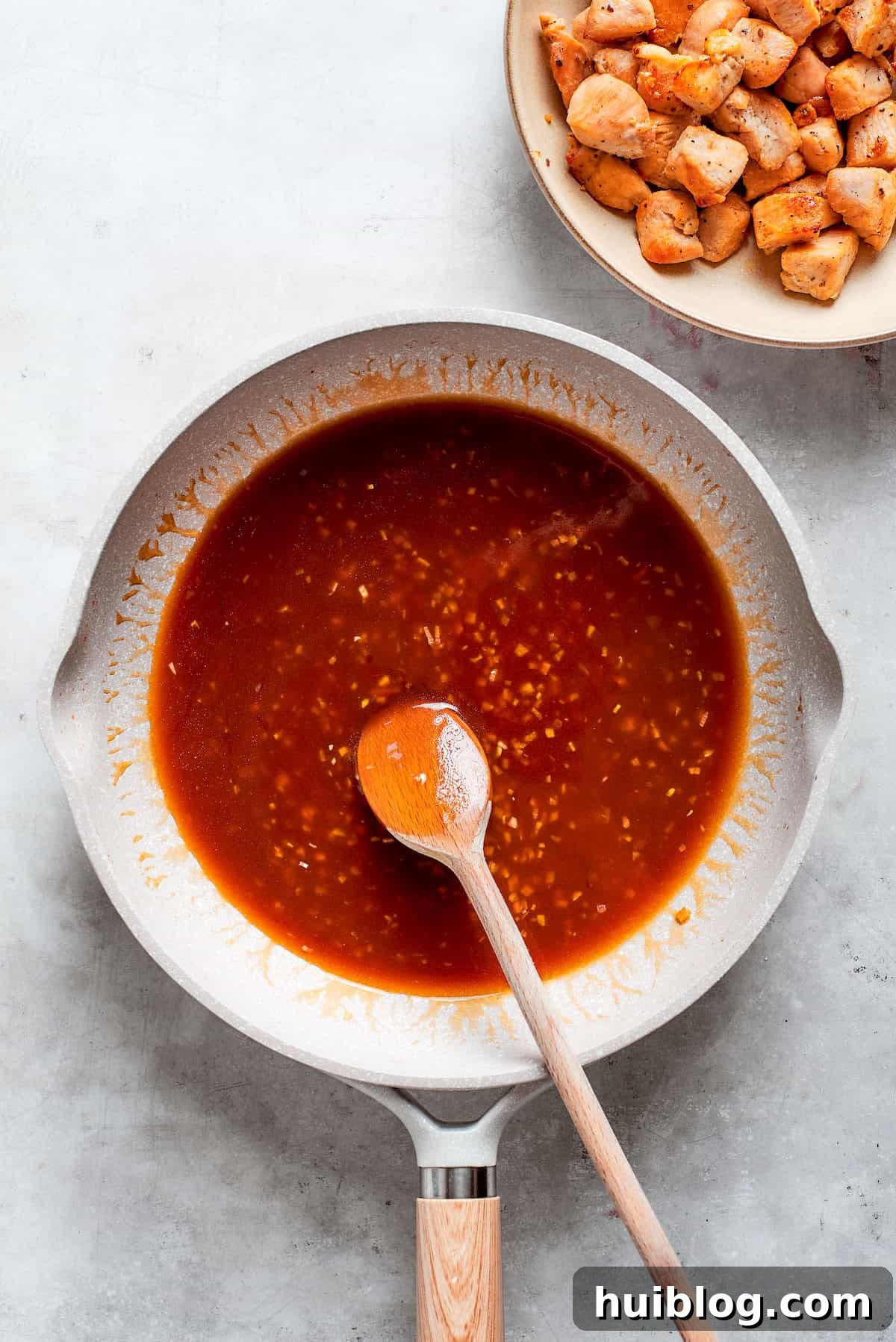 Perfectly Glazed Teriyaki Chicken 10 A spoon combines the teriyaki sauce in a pan.