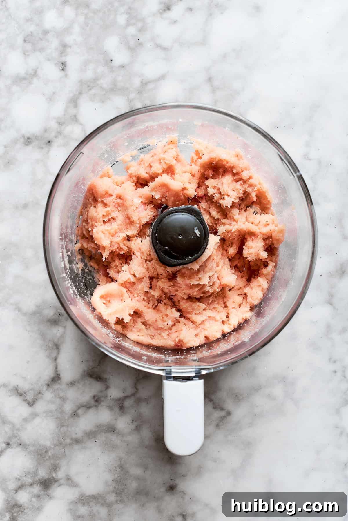 The food processor blends the chicken mixture into a smooth, cohesive paste, ideal for forming nuggets.