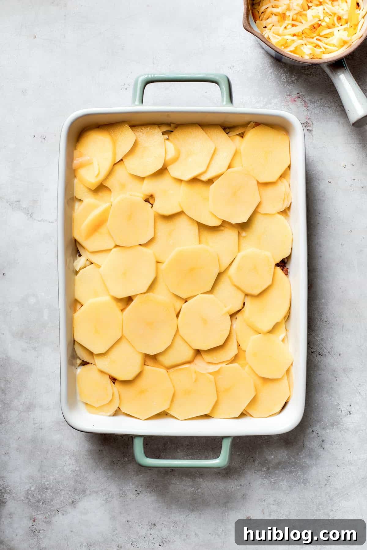 Hearty Ground Beef and Potato Bake 9 Another layer of thinly sliced potatoes is added over the meat and cheese in the casserole.