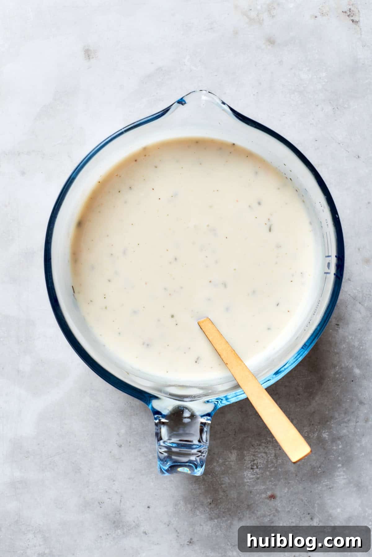The creamy soup mix, milk, sour cream, and Italian seasoning are thoroughly combined.